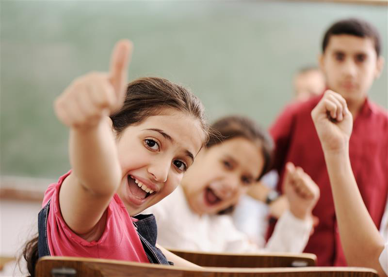Elev håller tumme upp i klassrummet